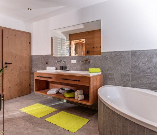 Modernes Badezimmer mit Badewanne und Dusche und eigener Panoramasauna
